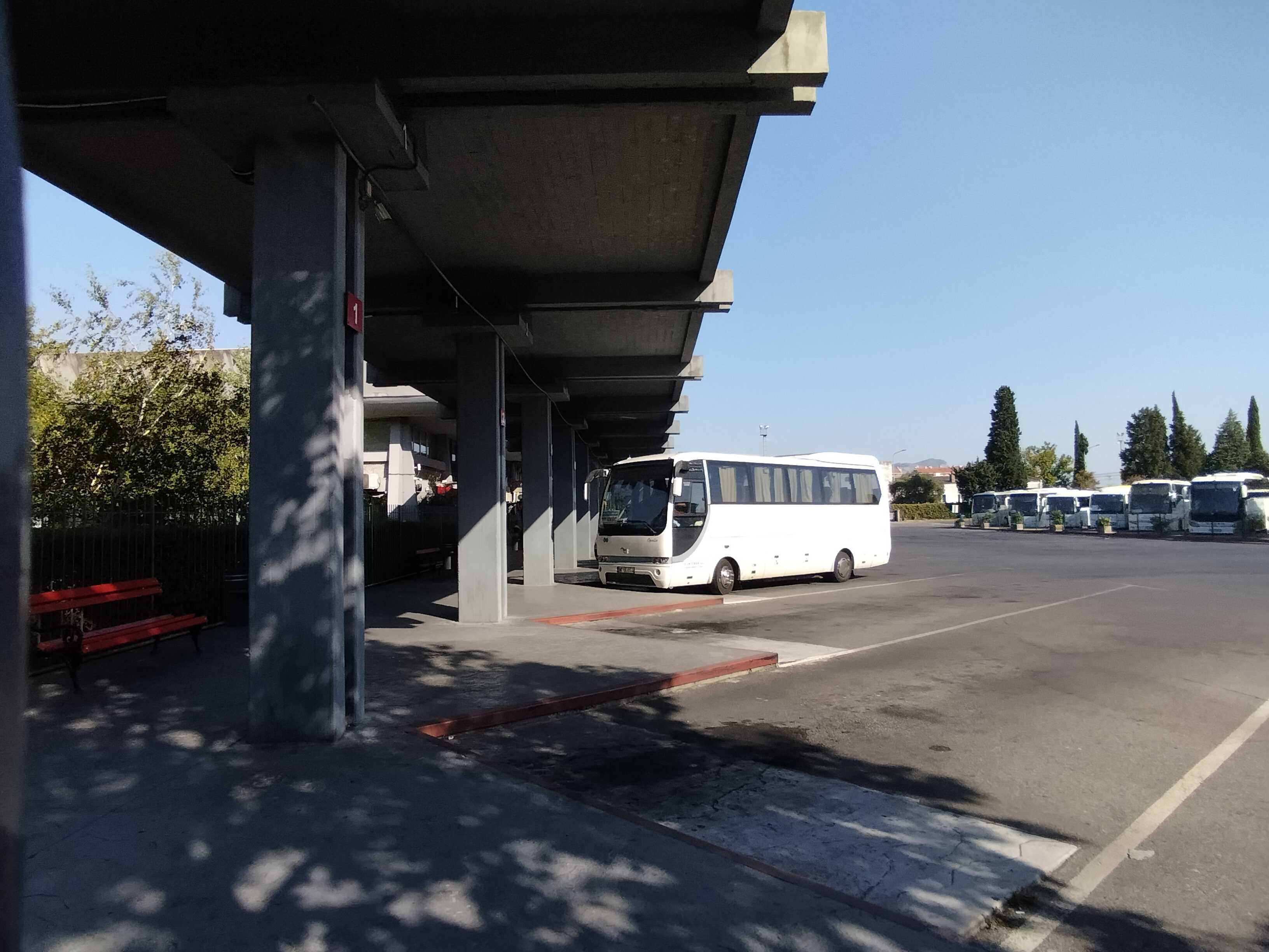 Boarding docks at the Central Bus Station in Podgorica. In the background multiple busses are parked.